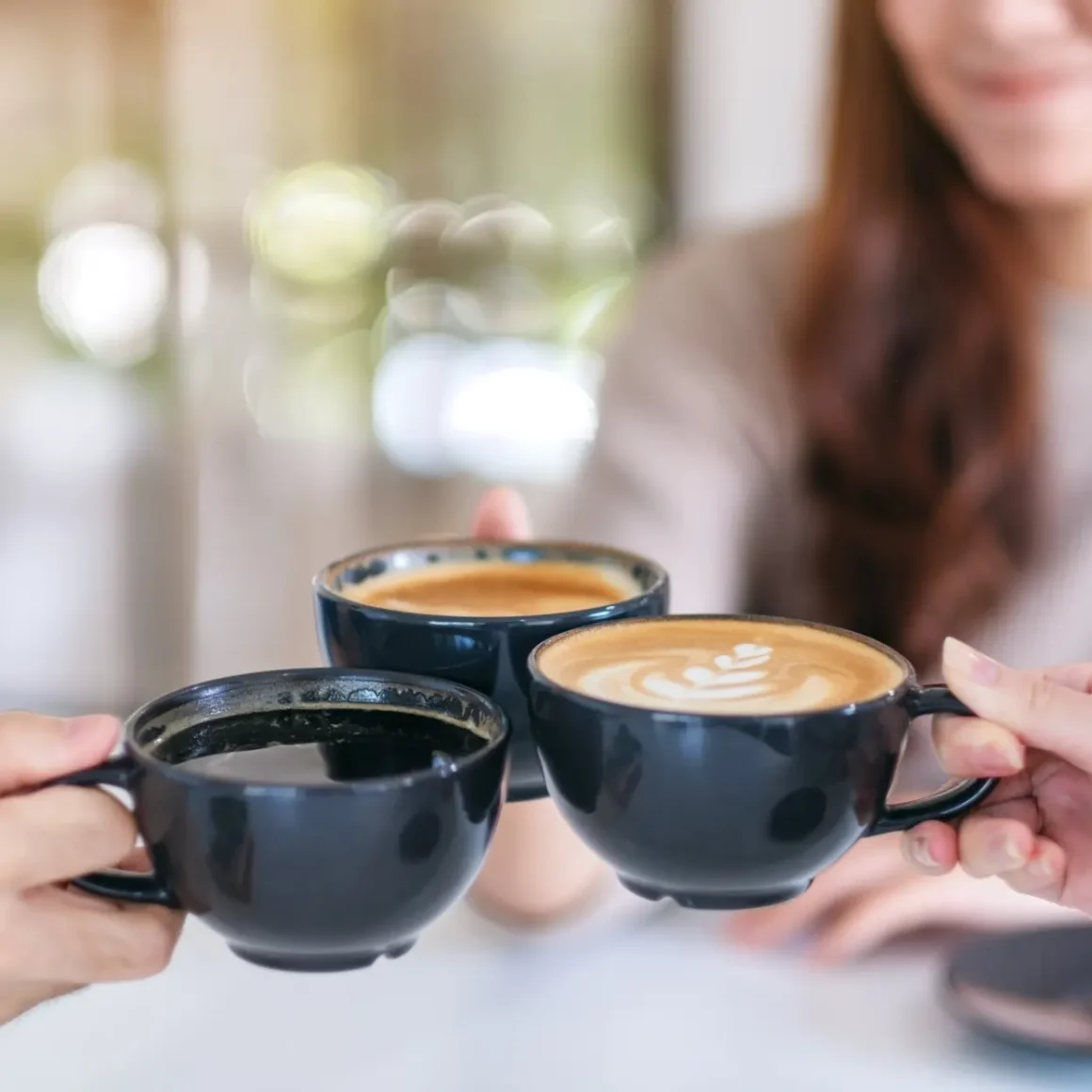 a group of people holding macchiato and latte coffee cups