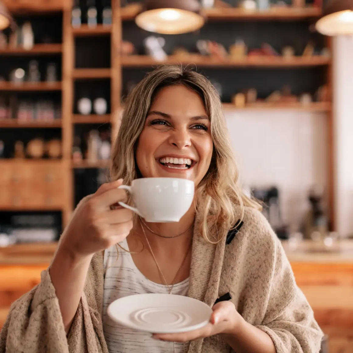 a women holding a cup of coffee and saucer