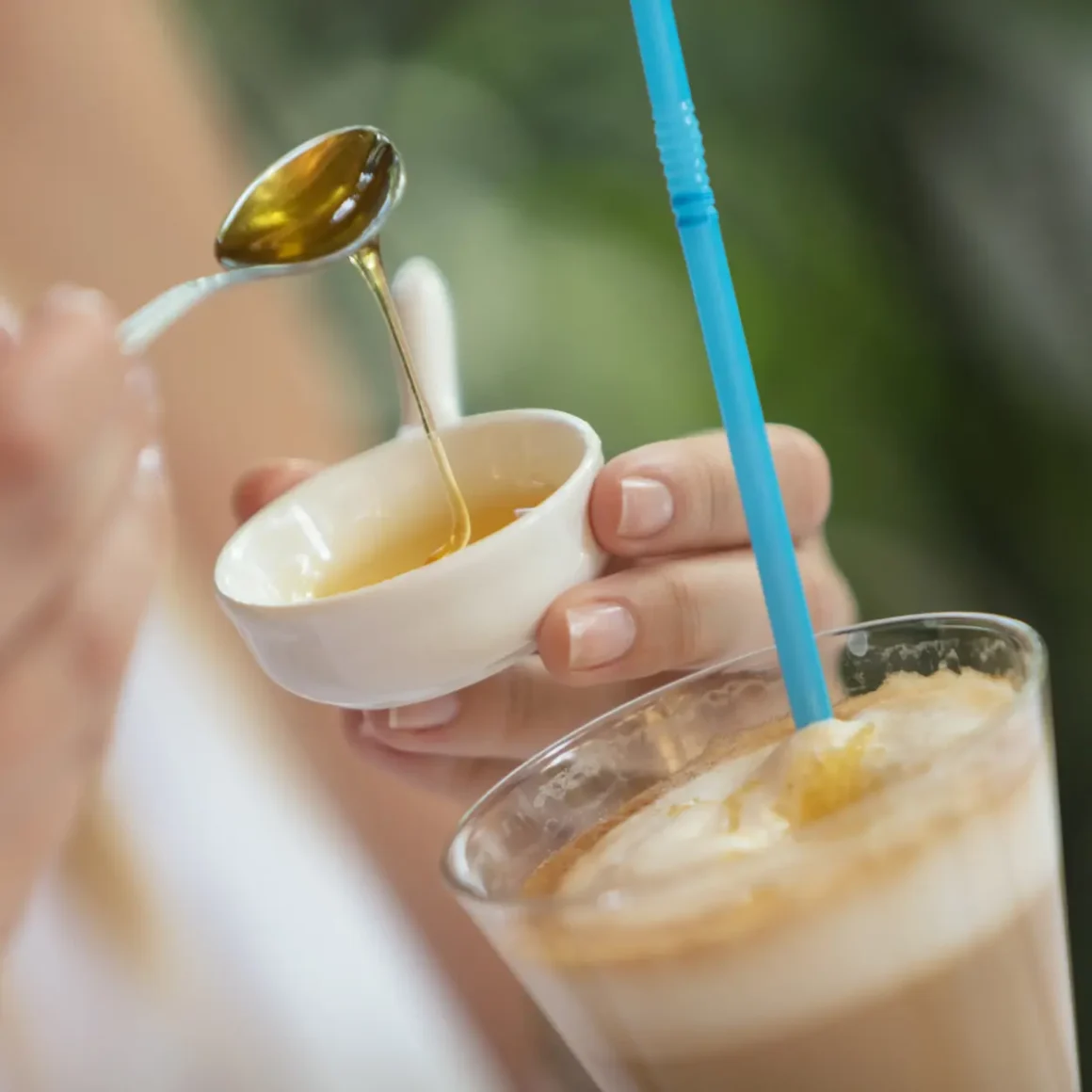 barista adding honey to a drink