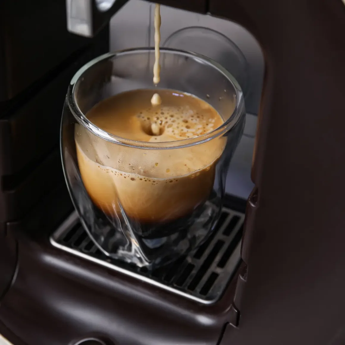 a espresso machine pouring a coffee into a glass