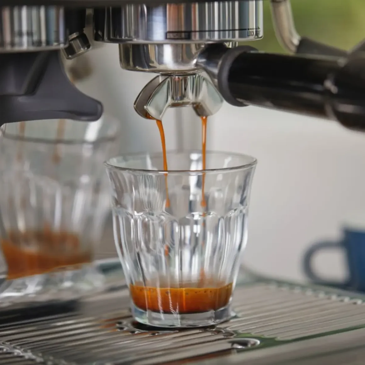 an espresso machine pouring coffee in a shot glass