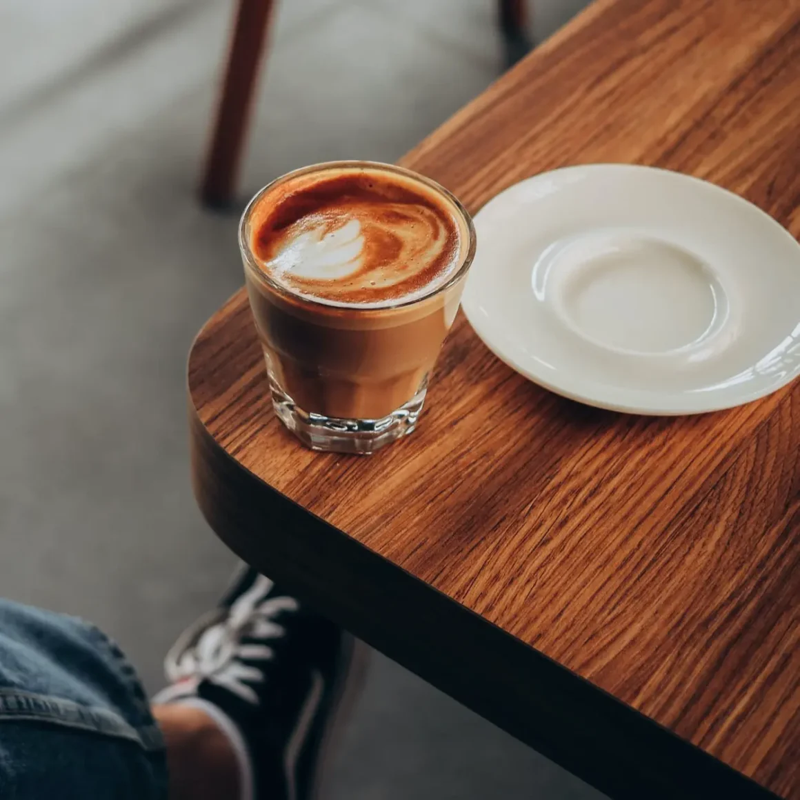 a glass cortado of coffee on a table