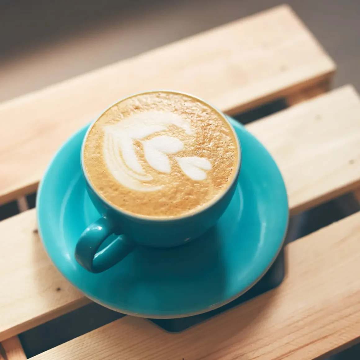 a blue cup of dry cappuccino with a foam design on it