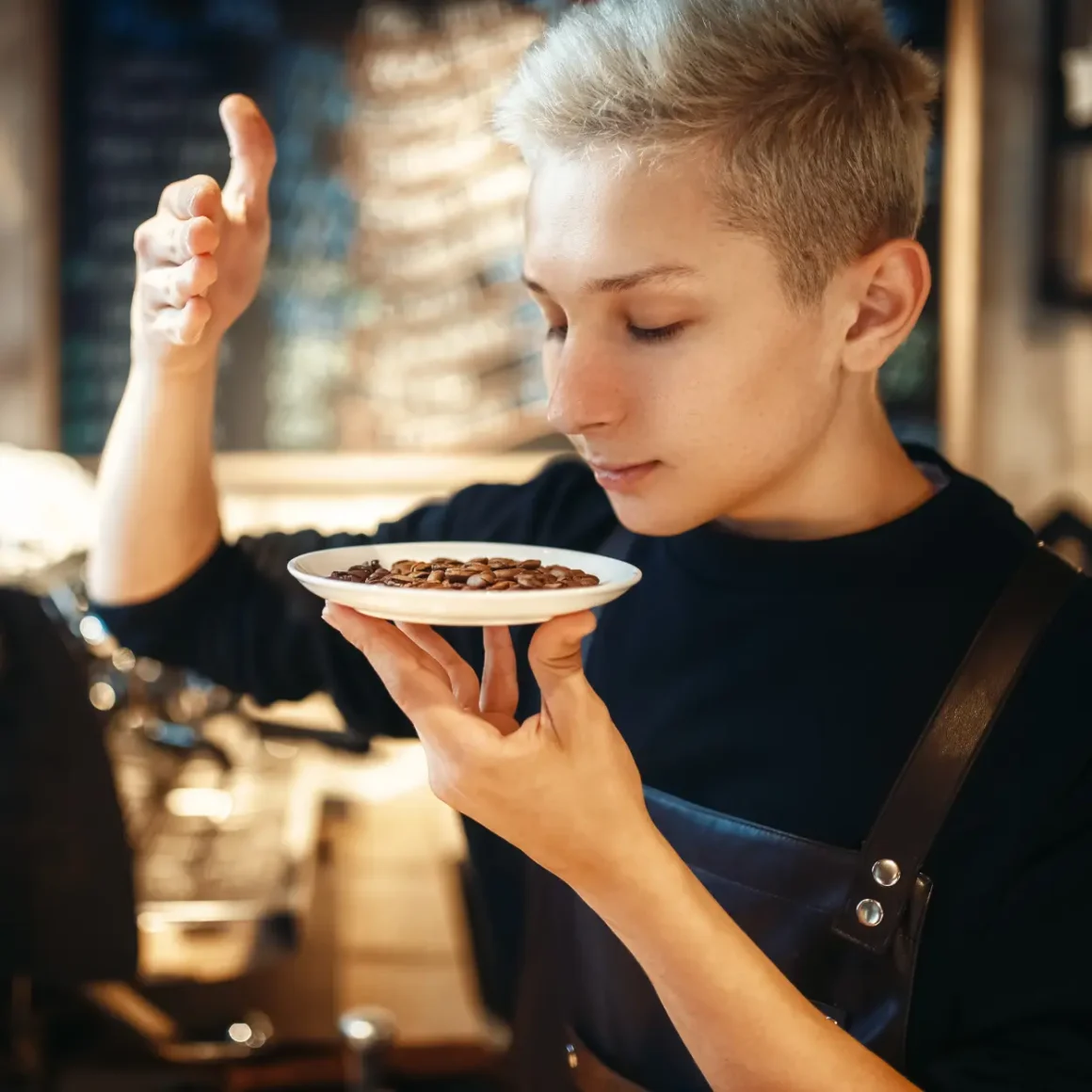 barista holding a plate of coffee beans