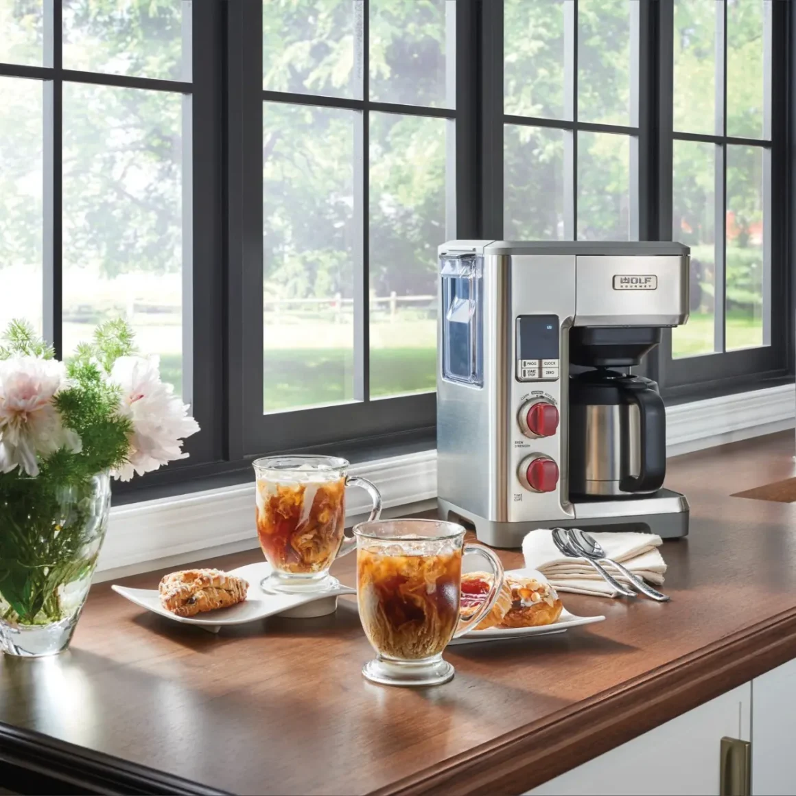 a wolf gourmet 10 cup coffee maker and cups of coffee on a table