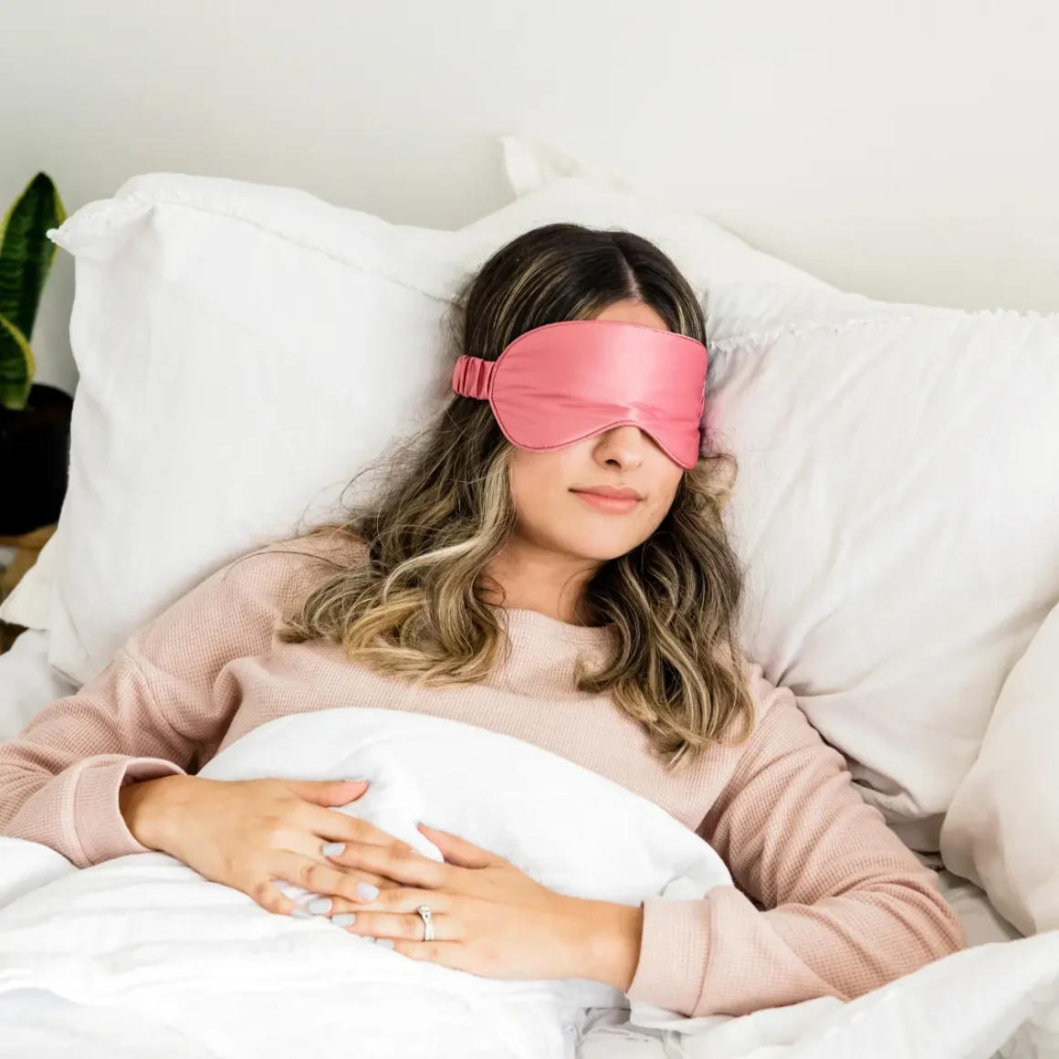 a women lying in bed with a sleep mask