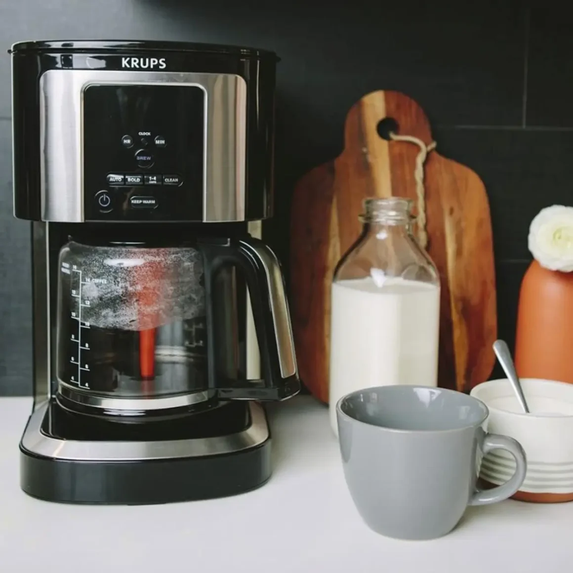 a krups simply brew 5-cup coffee maker and cups on a counter