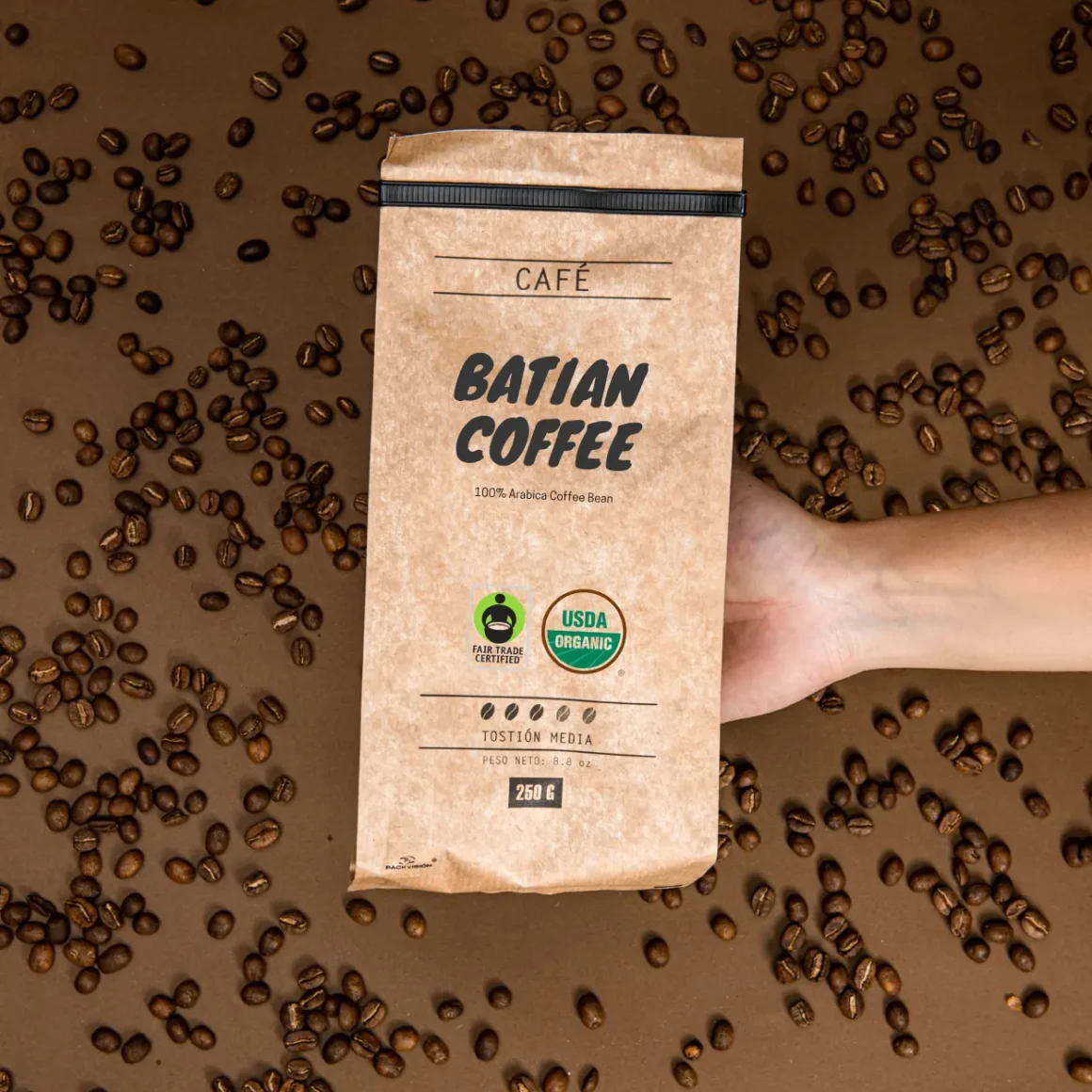 a hand holding a bag of batian coffee