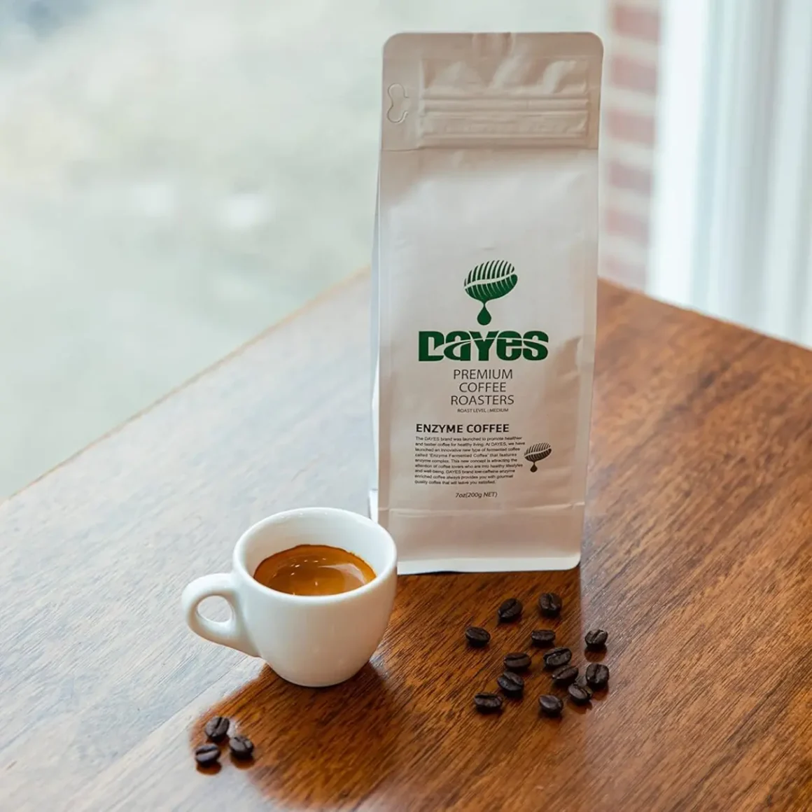 a dayes enzyme fermented whole bean coffee bag next to a cup of espresso