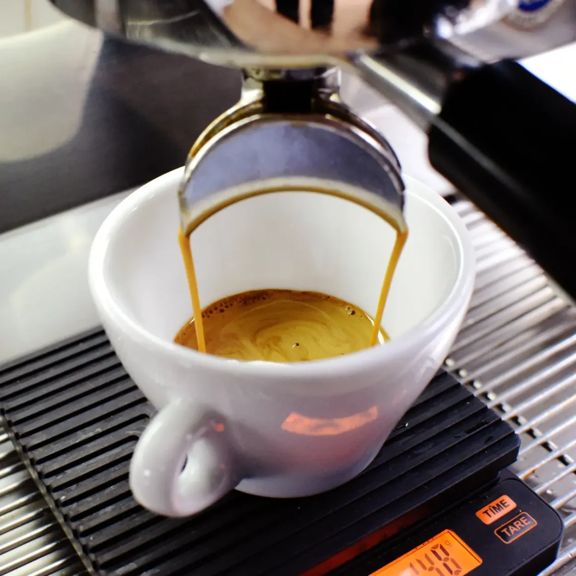 an espresso machine pouring a doppio espresso into a cup