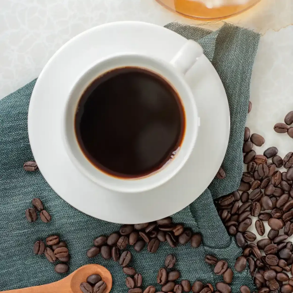 a cup of double brewed coffee and coffee beans