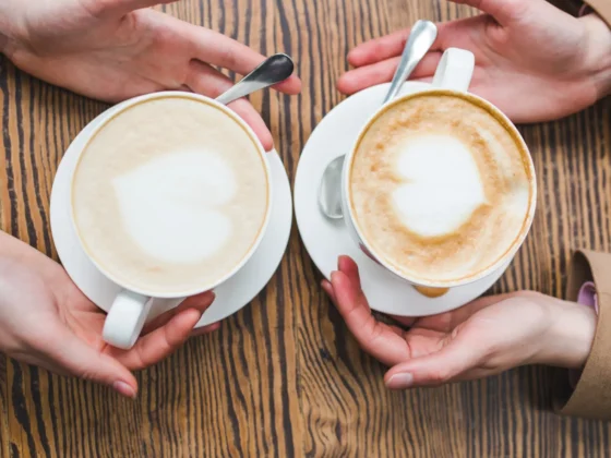 hands holding cups of wet cappuccino and dry cappuccino coffee