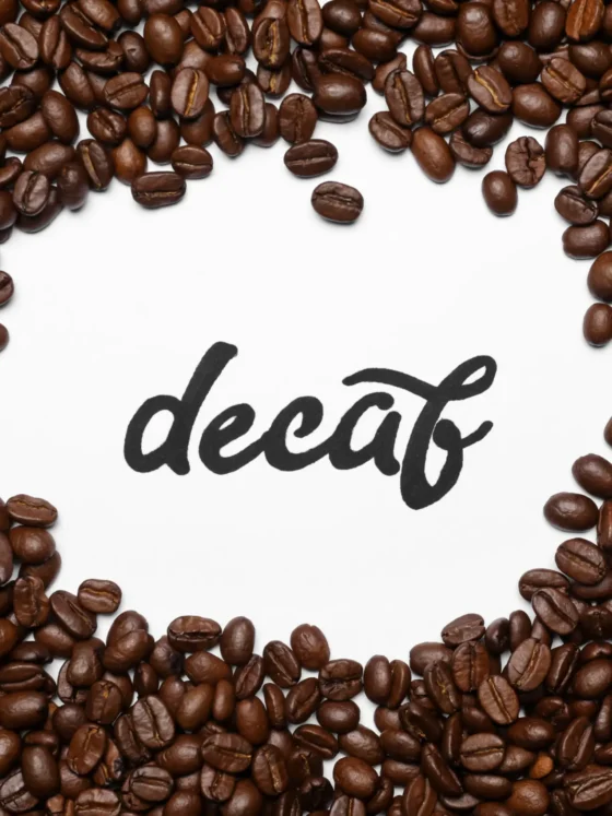a pile of decaf coffee beans with a white background