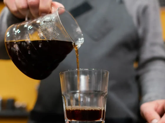 barista pouring a double brewed coffee into a glass