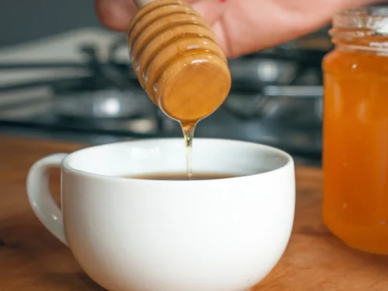 barista person pouring honey into a cup of coffee