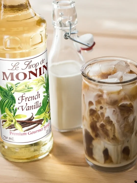 a bottle of monin french vanilla coffee syrup and a glass of milk