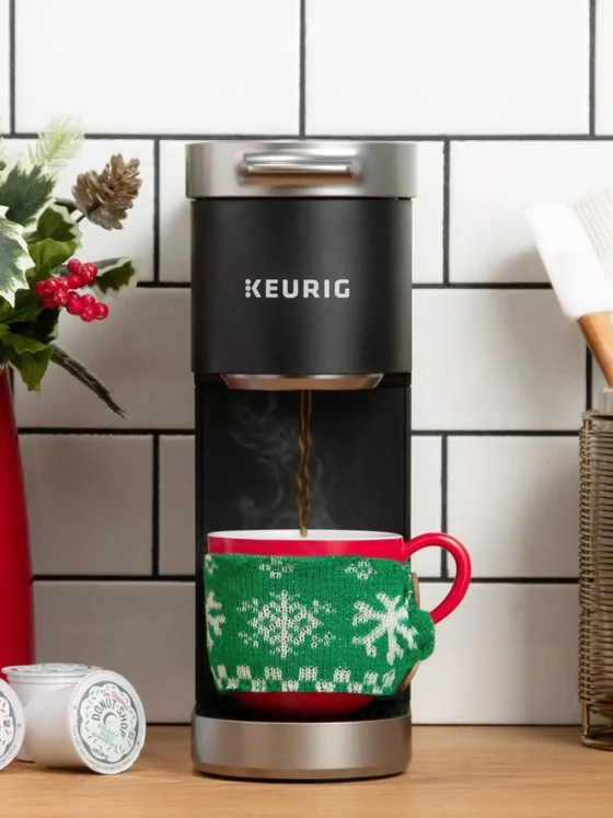 a keurig k-mini plus coffee maker with a cup in it