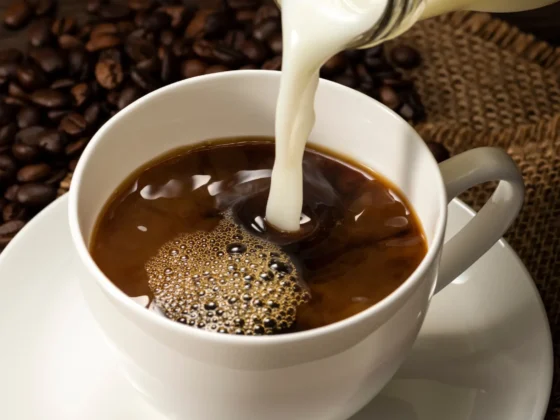 milk being poured into a cup of coffee