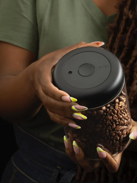 a person vacuum canister a jar of coffee beans