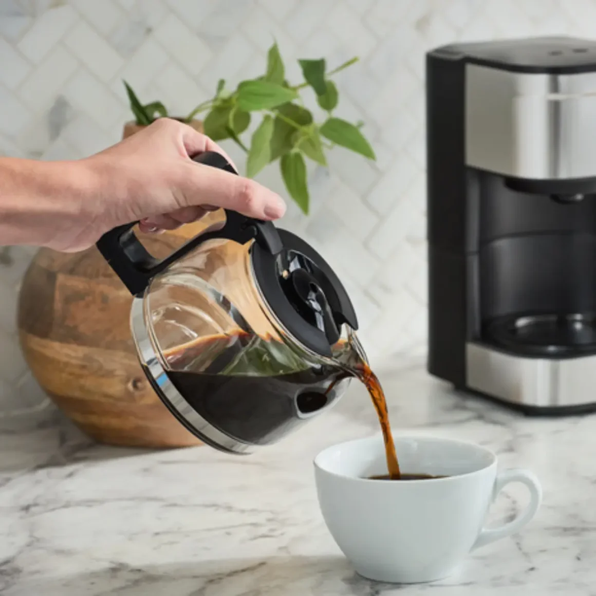 a person pouring coffee into a cup