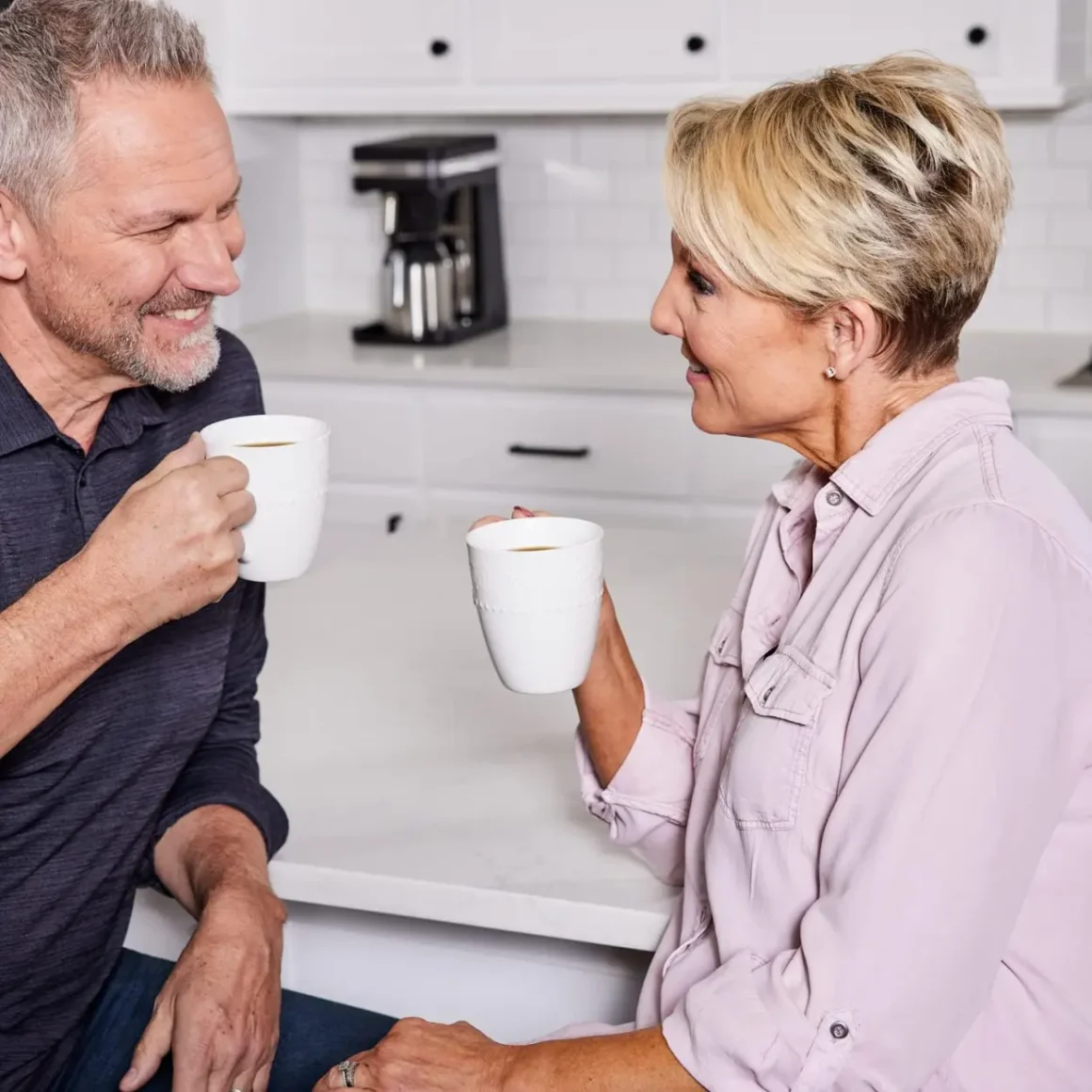 two persons holding a cups of coffee