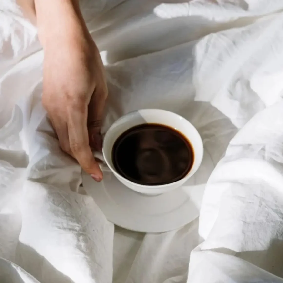a hand holding a cup of coffee