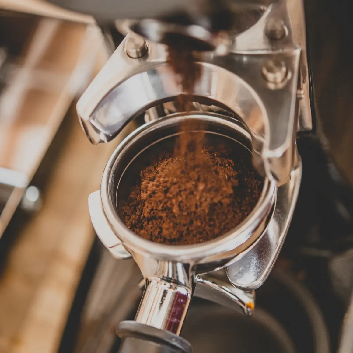 ground coffee being poured in a coffee grinding machine