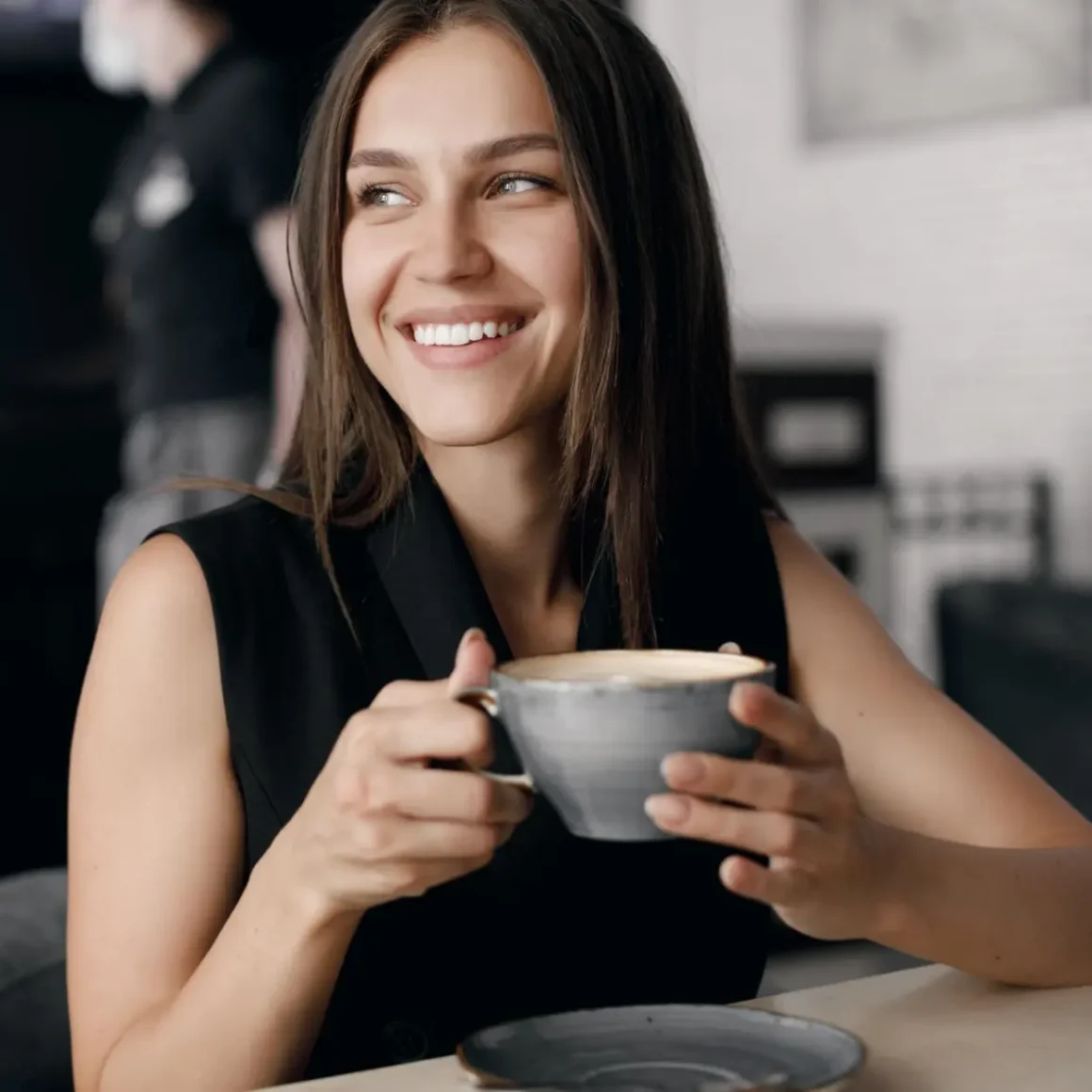 a woman holding a cup of latte