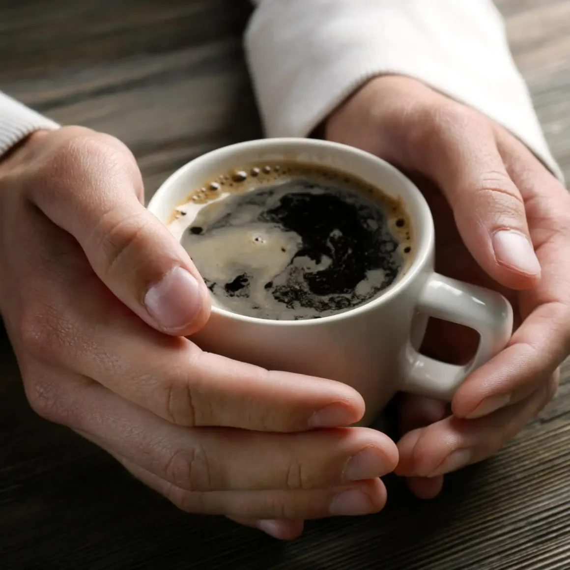 a person holding a cup of coffee