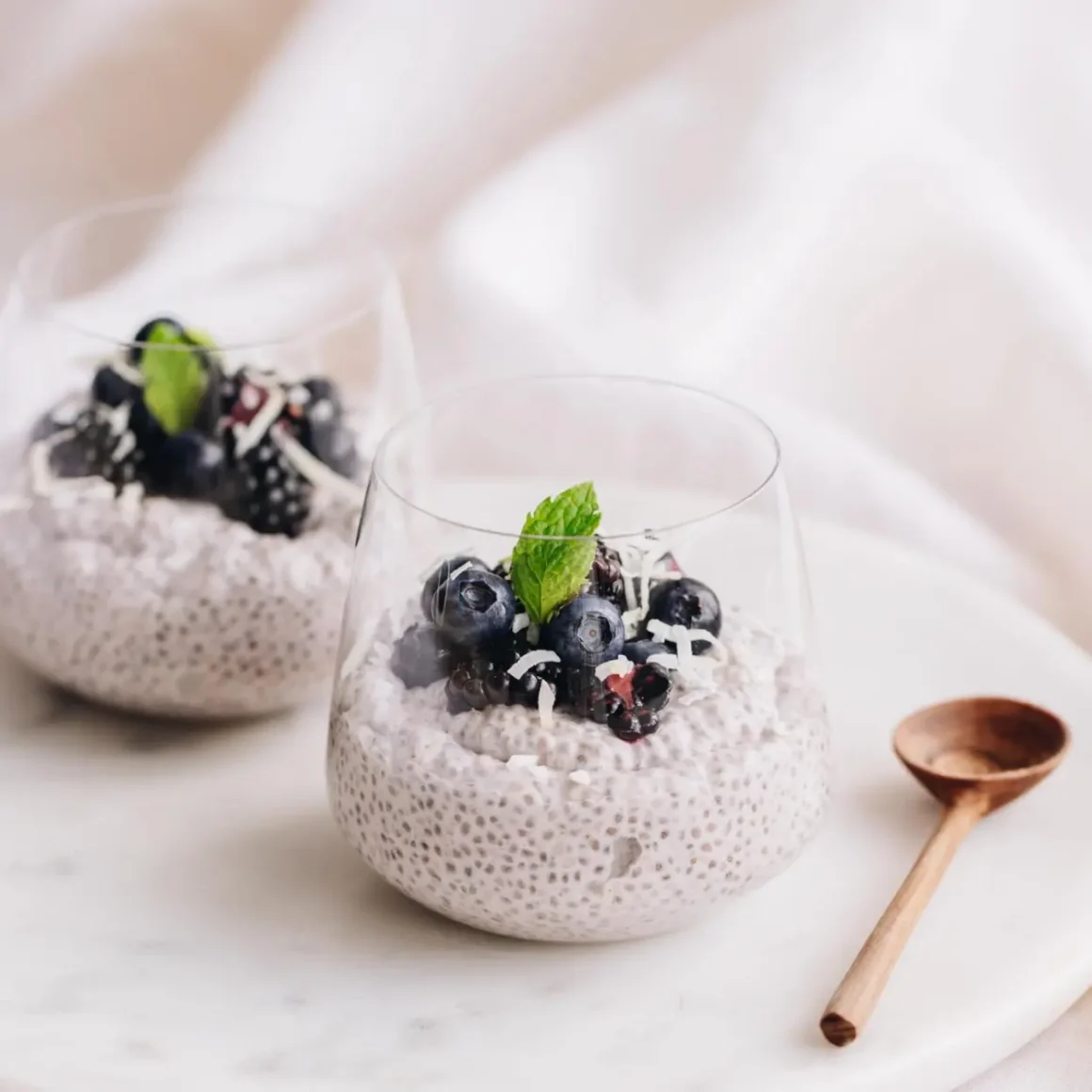 two glasses of food with berries and a spoon