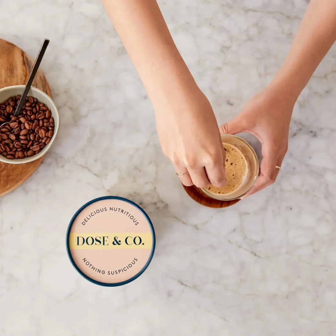 a person holding a glass of dose & co pure collagen creamer