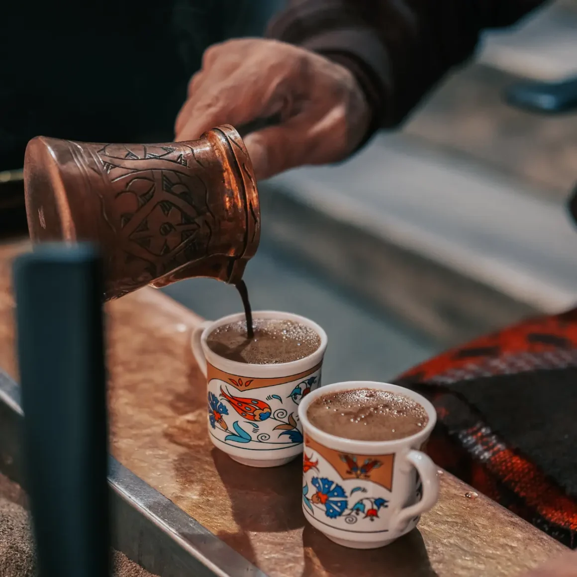 barista pouring turkish coffee into cups