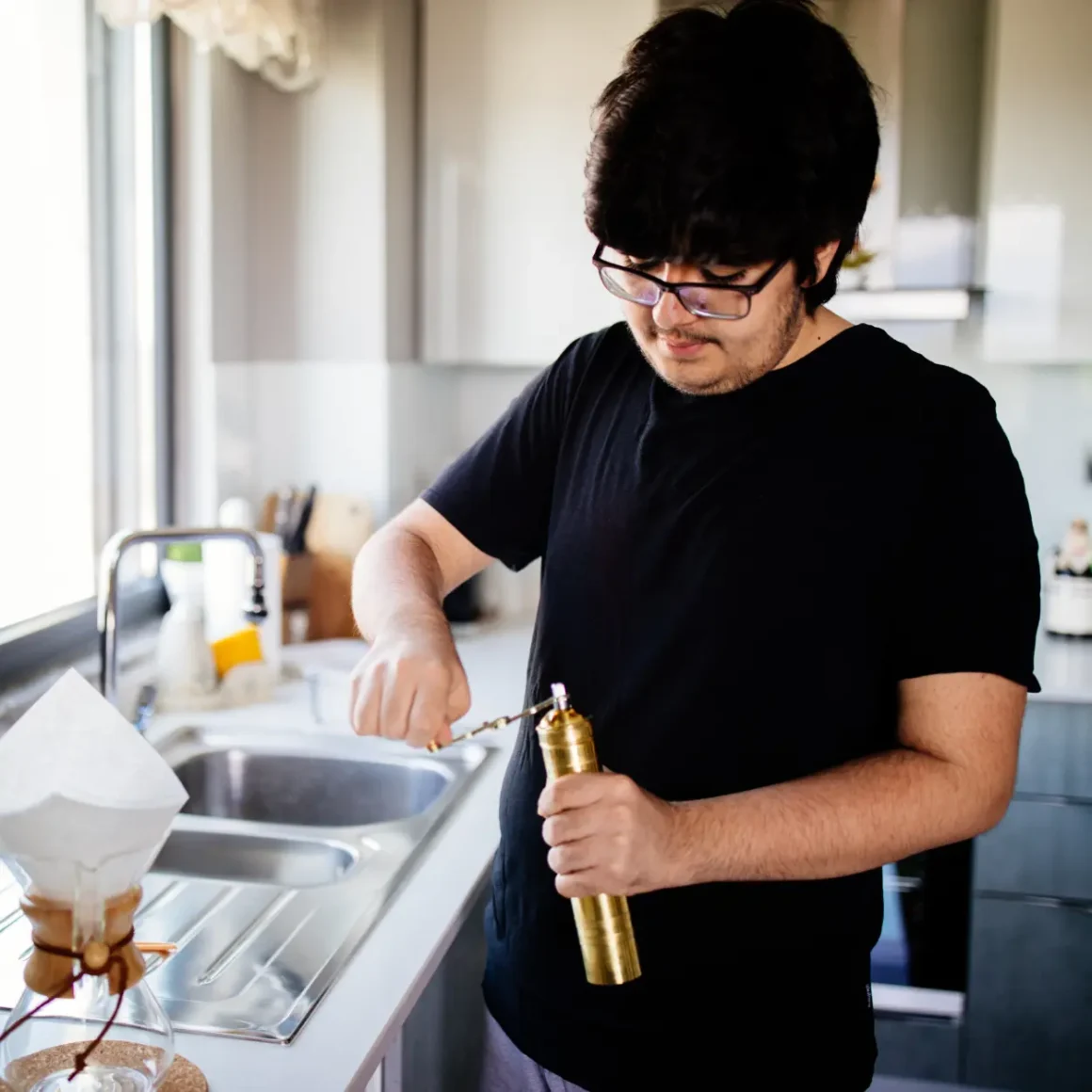 a person using a turkish coffee grinder