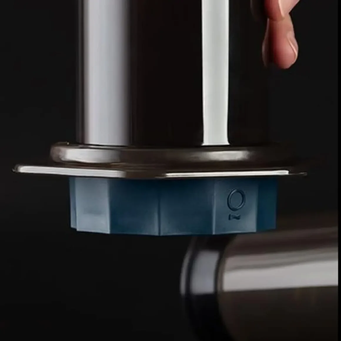a hand holding a coffee maker with a fellow prismo flow control filter cap attached with it