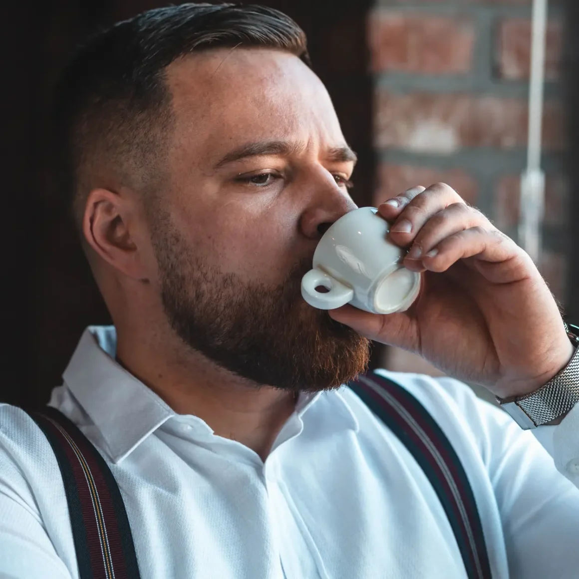 a man drinking a coffee from a cup