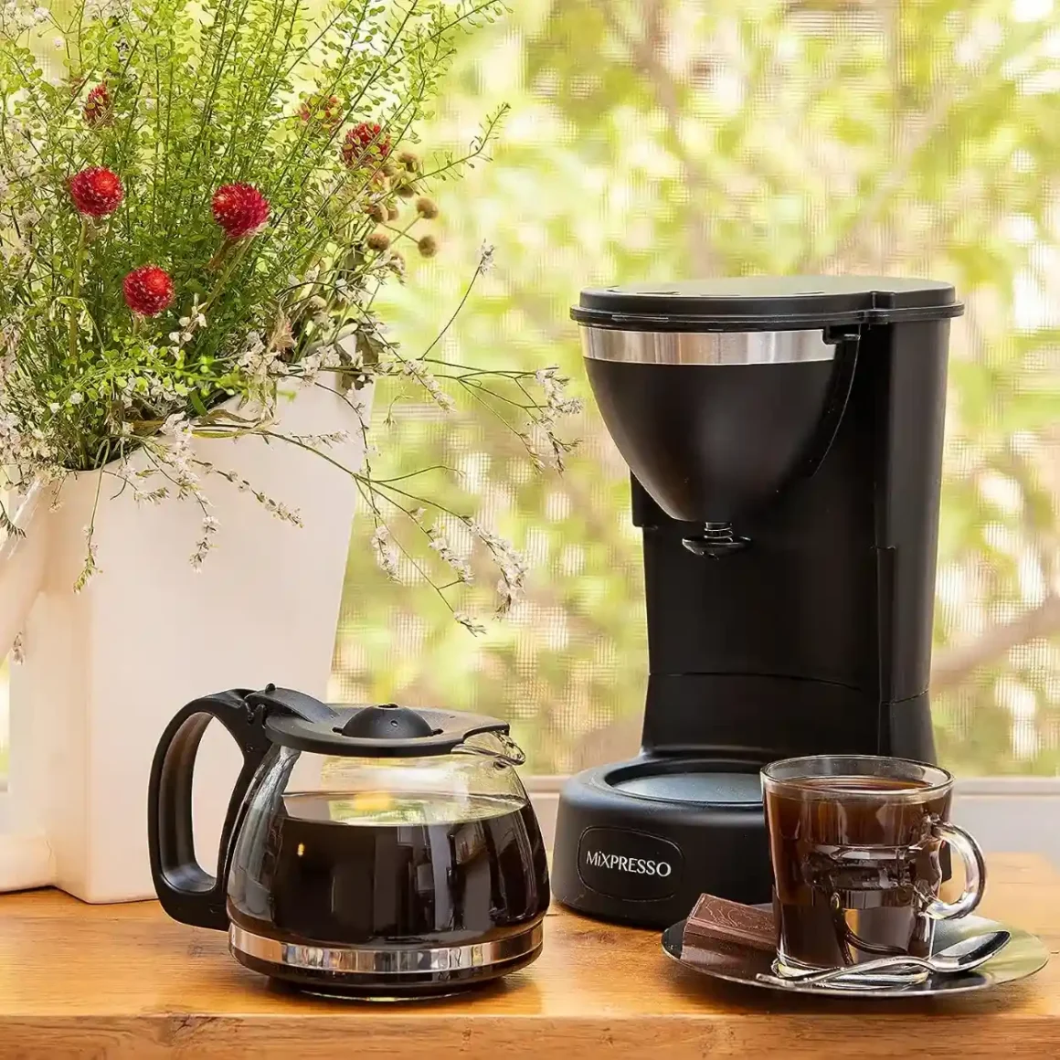 a coffee maker and a cup of coffee