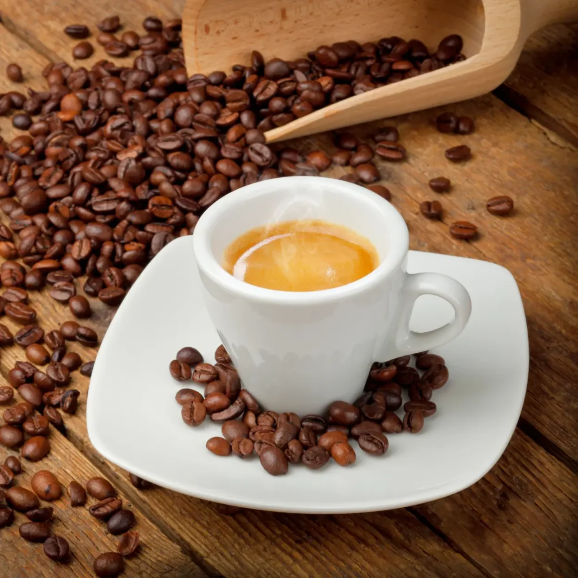 a cup of coffee on a saucer with medium roast coffee beans