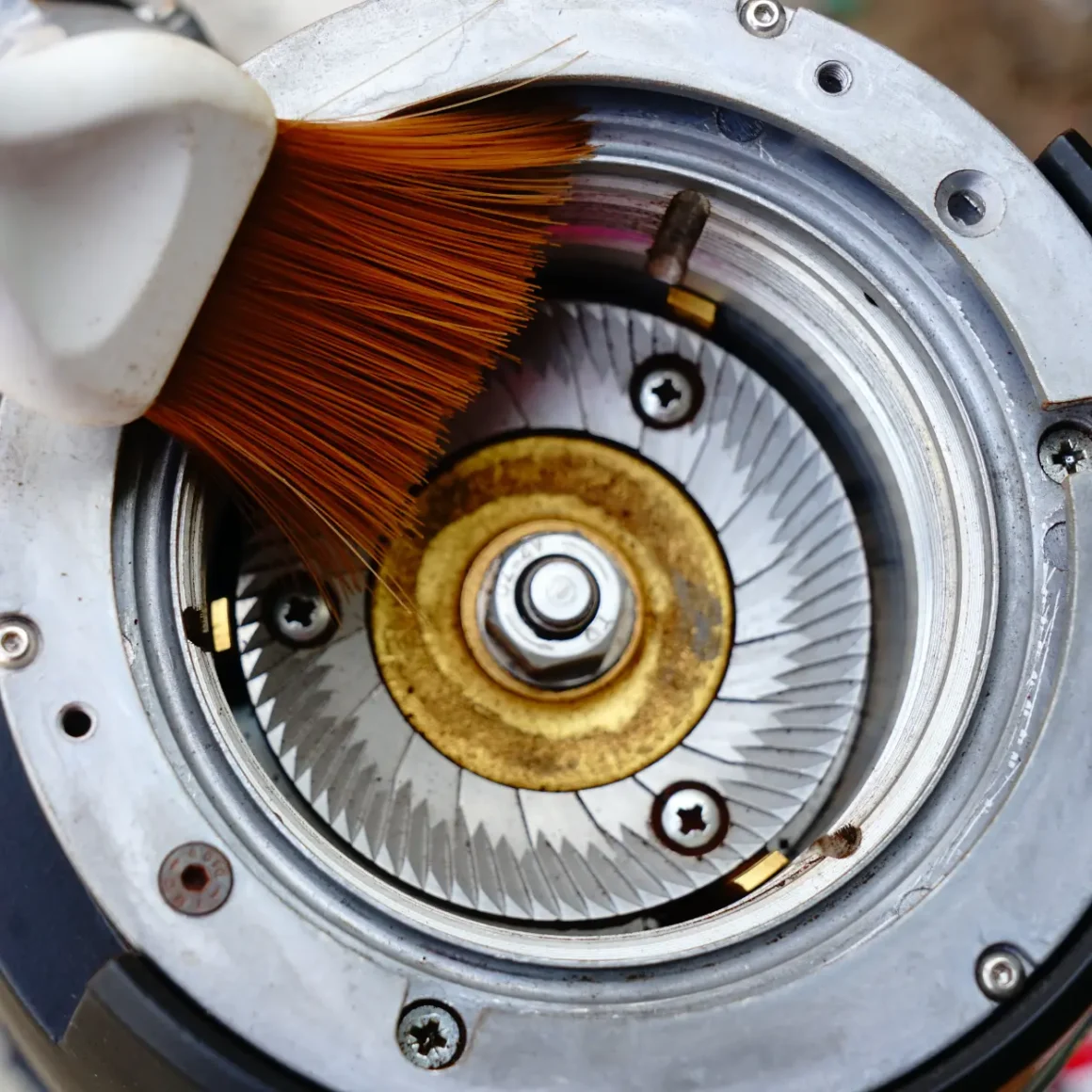 a brush cleaning internal parts of a turkish coffee grinder