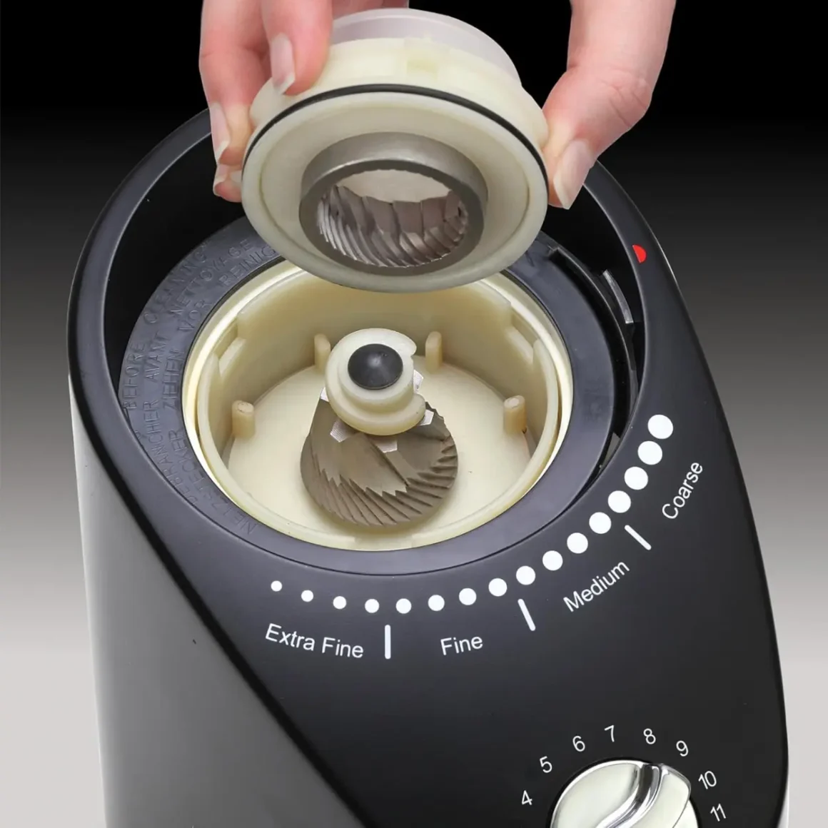 a hand opening a turkish coffee grinder