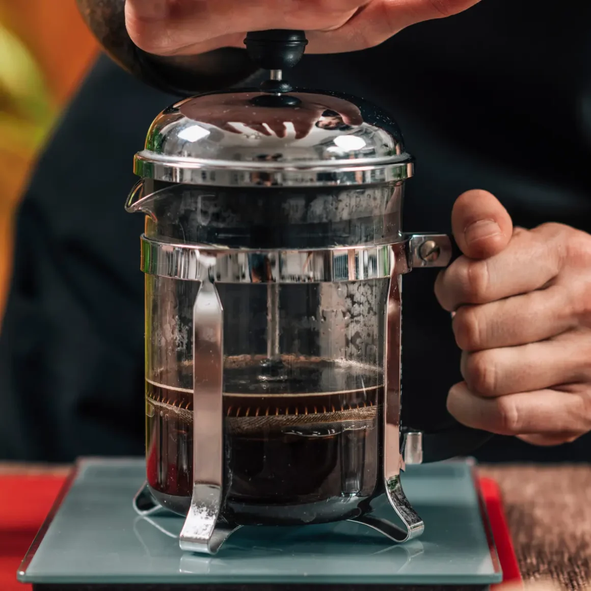 barista pouring a double brewed coffee into a french press