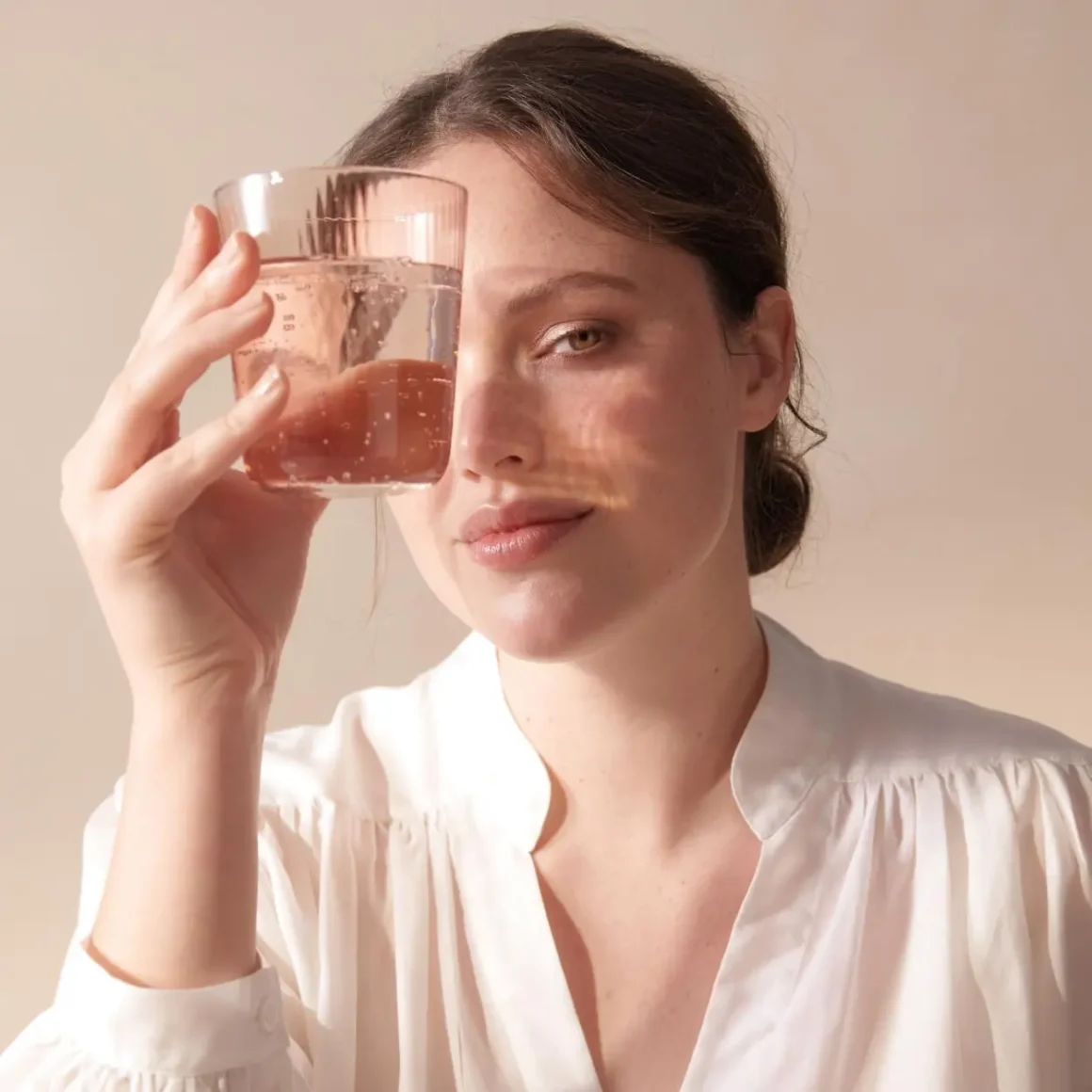 a woman holding a glass of water