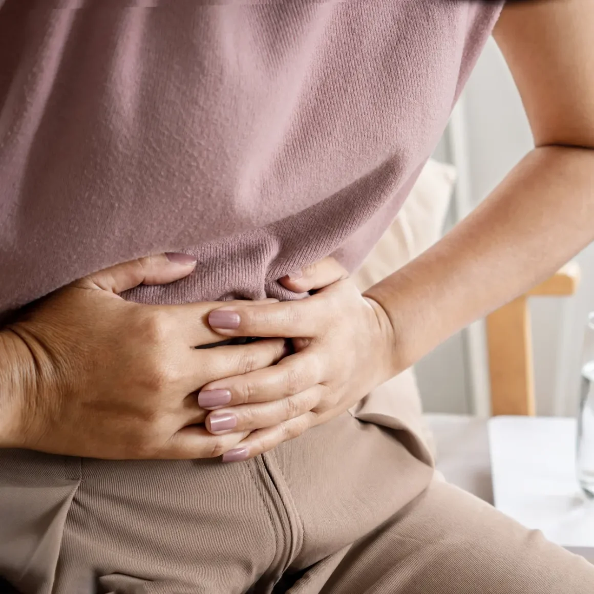 a woman holding her stomach from digesting collagen coffee creamer