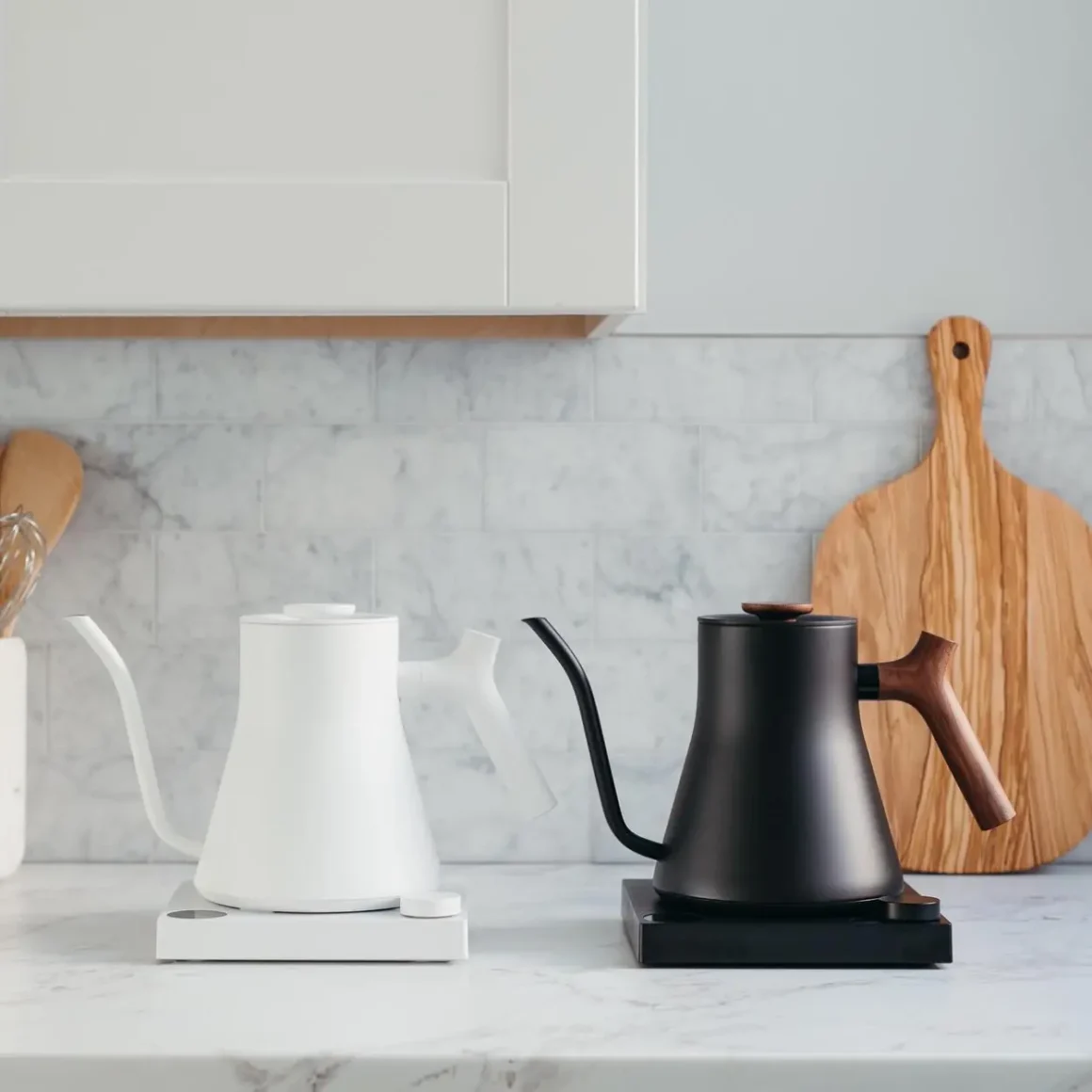 a black and a white electric kettle on a counter