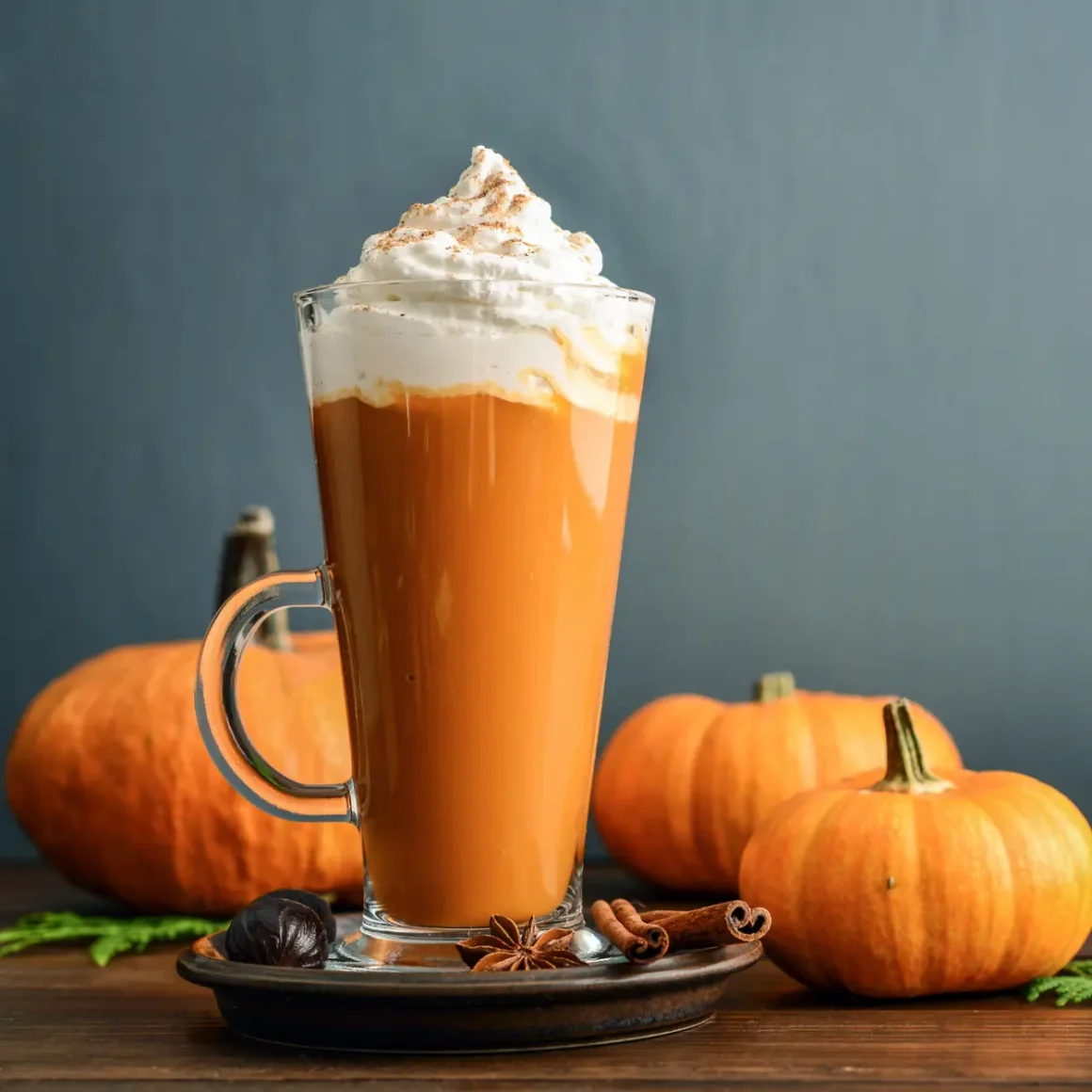 a glass of latte with whipped cream and spices