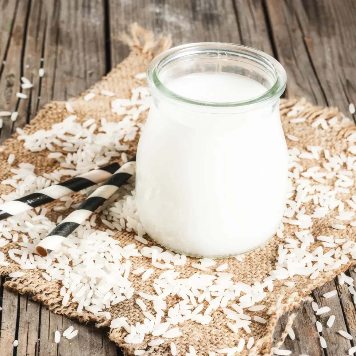 a glass jar of rice milk and rice on a burlap cloth