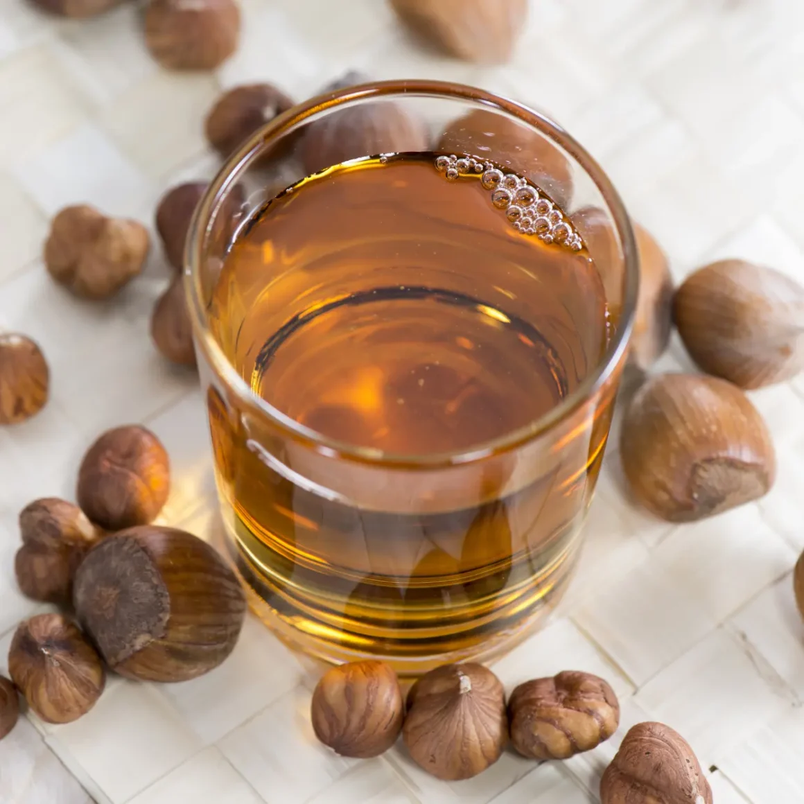 a glass of coffee syrup next to nuts