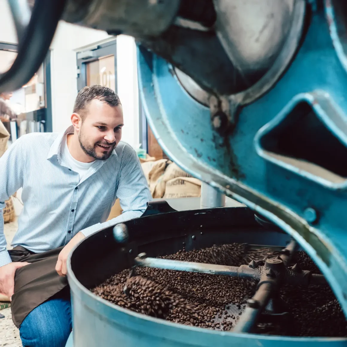 a person grinding coffee in a large machine