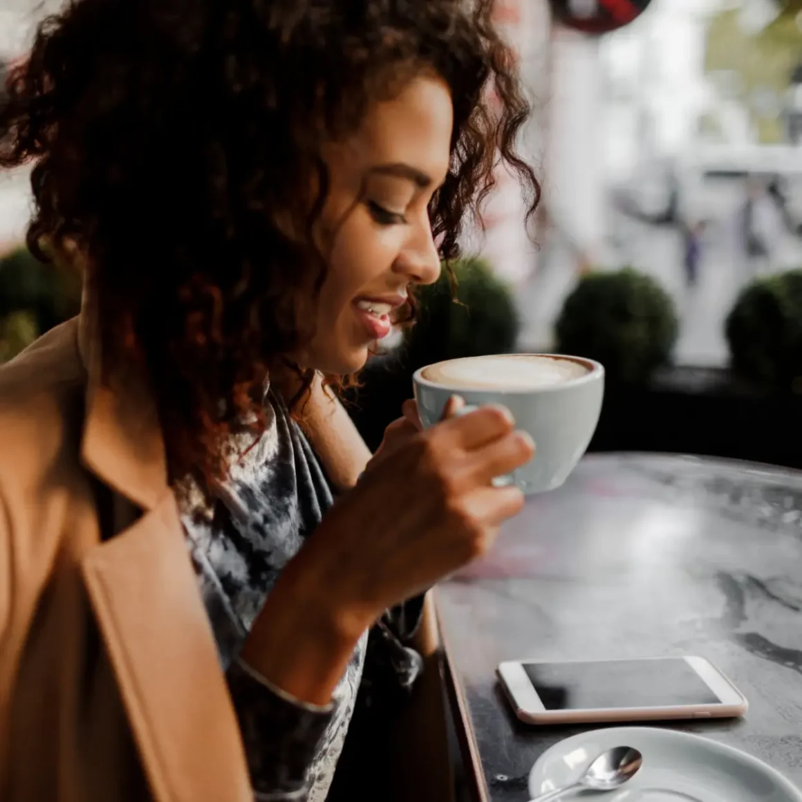 a woman holding a cup of dry cappuccino coffee