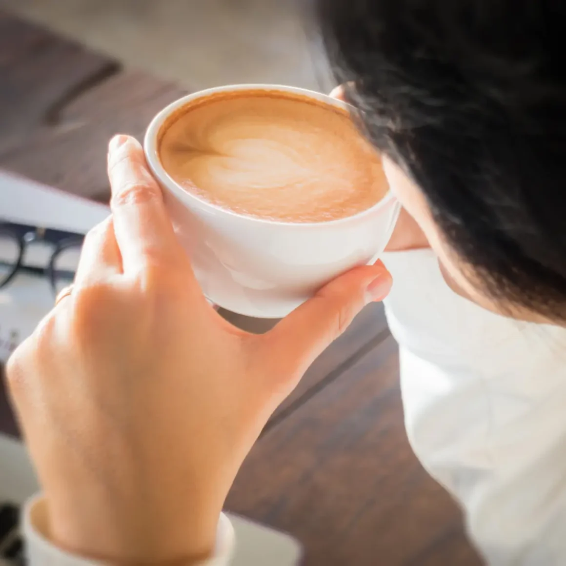 a person holding a cup of latte