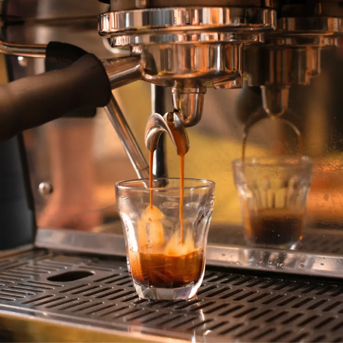 a coffee machine pouring a piccolo coffee into a glass
